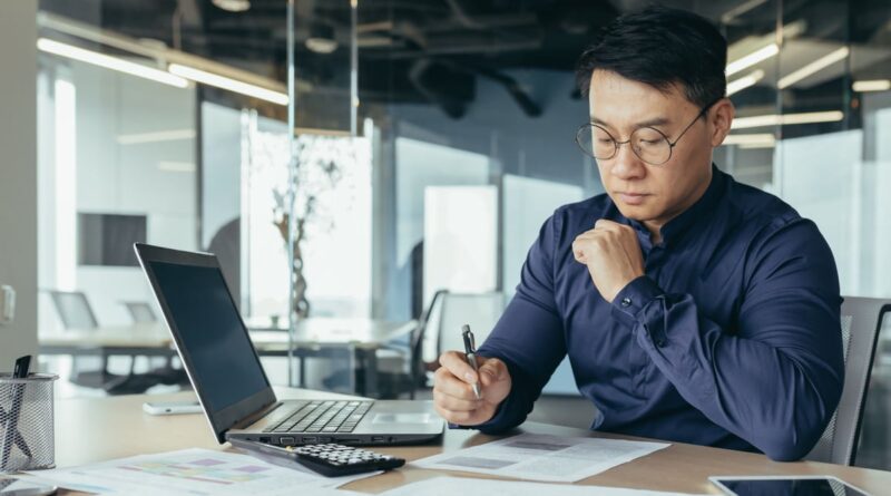 Investor sitting at a desk reviewing paperwork.
